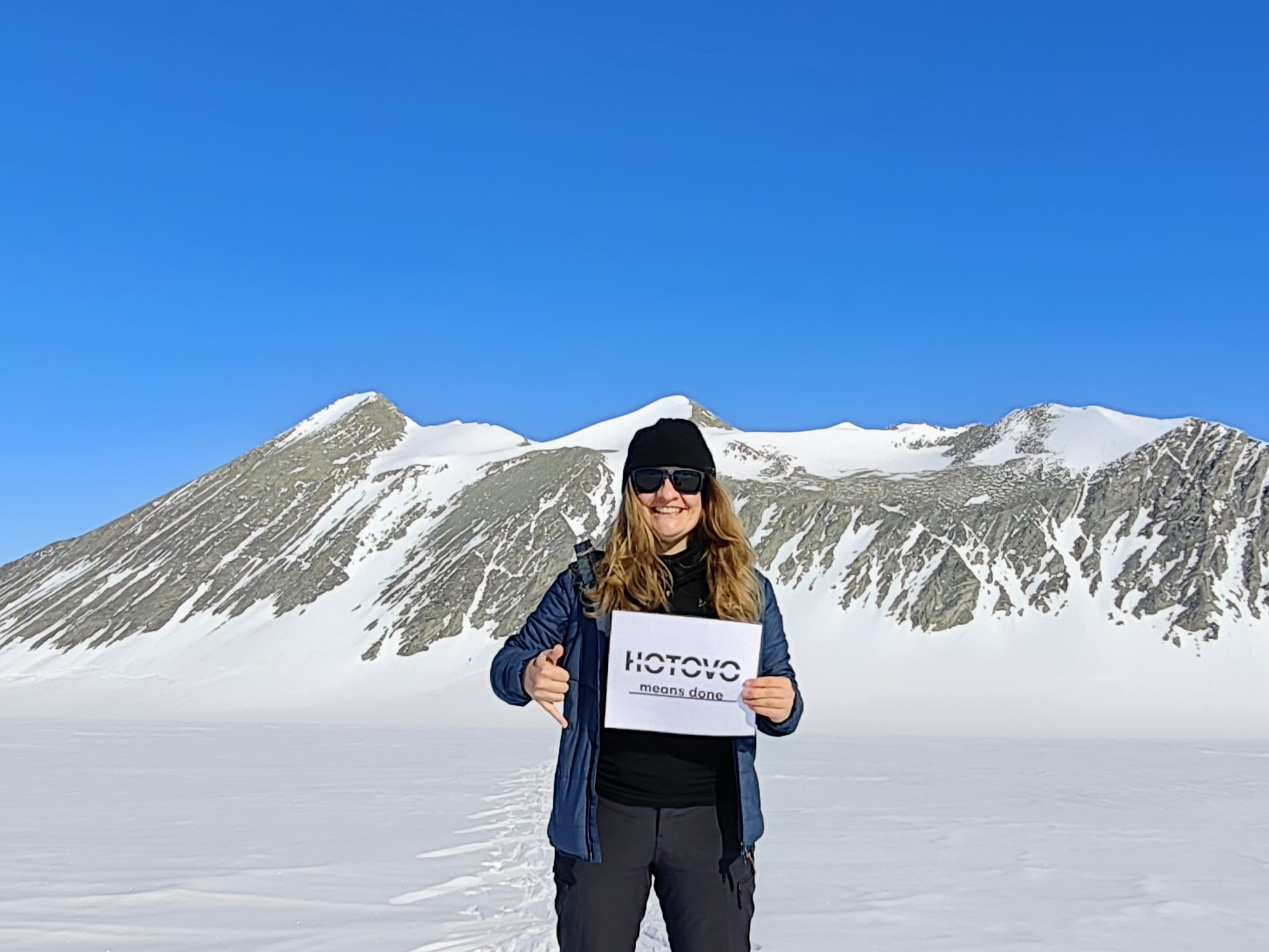Musilova holding logo Hotovo with montains in the background